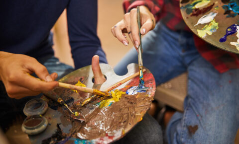 Woman and man mix oils on a palette